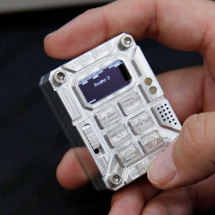 A Cyber Fidget held in a hand, playing a brick-breaking game on its screen